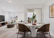 Thumbnail 10 of 13 - A modern dining room with a white table and chairs.
