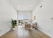 Thumbnail 8 of 44 - A living room with a wooden floor and a large window.