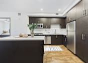 Thumbnail 15 of 40 - A modern kitchen with dark wood cabinets and stainless steel appliances.