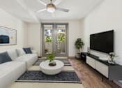 Thumbnail 18 of 40 - A modern living room with a white sofa, a round coffee table, and a flat-screen TV.