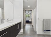 Thumbnail 24 of 40 - A bathroom with a white sink and a mirror.
