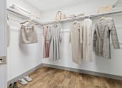 Thumbnail 22 of 40 - A row of clothes are hung on a rail in a white room.