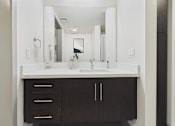 Thumbnail 25 of 40 - A bathroom with a sink and a mirror.