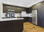 Thumbnail 1 of 40 - A modern kitchen with dark wood cabinets and stainless steel appliances.