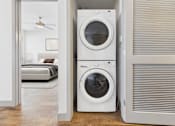 Thumbnail 11 of 40 - A white washing machine and dryer in a laundry room.