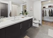Thumbnail 14 of 40 - A bathroom with a white countertop and black cabinets.