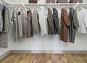 Thumbnail 10 of 40 - A row of clothes hanging on a rack.