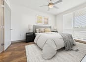 Thumbnail 8 of 40 - A bedroom with a bed, a ceiling fan, and a rug.