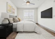 Thumbnail 7 of 40 - A bedroom with a bed, nightstand, and a ceiling fan.