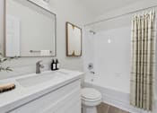 Thumbnail 9 of 73 - A white bathroom with a toilet, sink, and shower.