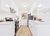 Thumbnail 1 of 73 - A kitchen with white cabinets and appliances.