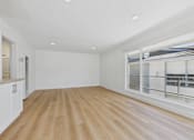 Thumbnail 109 of 228 - A spacious room with wooden flooring and white walls.
