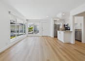 Thumbnail 105 of 228 - A spacious kitchen with white cabinets and a wooden floor.