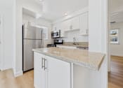 Thumbnail 101 of 228 - A kitchen with a granite countertop and stainless steel appliances.