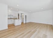 Thumbnail 102 of 228 - A spacious room with wooden flooring and white walls.