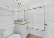 Thumbnail 119 of 228 - A white bathroom with a toilet, sink, and shower.
