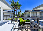 Thumbnail 112 of 228 - A modern house with a palm tree in front.