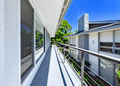 Thumbnail 113 of 228 - A balcony with a metal railing and glass doors leading to a patio.