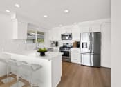 Thumbnail 2 of 135 - a white kitchen with a large island and stainless steel appliances