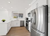 Thumbnail 1 of 135 - a white kitchen with stainless steel appliances and white cabinets