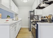Thumbnail 1 of 65 - A kitchen with white cabinets and a black refrigerator.