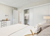 Thumbnail 8 of 65 - A bedroom with a bed, dresser, and closet.