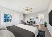 Thumbnail 9 of 38 - A bedroom with a large bed and a ceiling fan.
