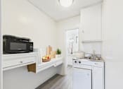 Thumbnail 11 of 38 - A small kitchen with a microwave, oven, and sink.