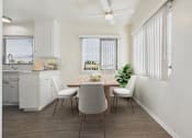 Thumbnail 2 of 91 - A modern kitchen with a dining table and chairs.