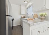 Thumbnail 1 of 91 - A kitchen with a refrigerator, countertop, and cabinets.