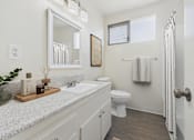 Thumbnail 8 of 91 - A bathroom with a white toilet, sink, and a mirror.