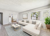 Thumbnail 4 of 38 - A living room with a white couch and a glass coffee table.