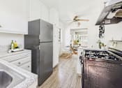 Thumbnail 1 of 38 - A modern kitchen with a black refrigerator and stove.