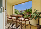 Thumbnail 42 of 53 - A patio with a table and chairs and a potted plant.