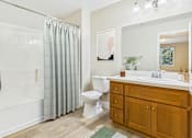 Thumbnail 24 of 53 - A bathroom with a white toilet, a white sink, and a white bathtub with a shower curtain.
