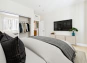 Thumbnail 30 of 53 - A bedroom with a large bed and a flat screen TV mounted on the wall.