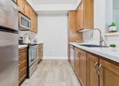 Thumbnail 25 of 53 - A kitchen with wooden cabinets and a stainless steel refrigerator.