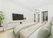 Thumbnail 29 of 53 - A bedroom with a large bed and a flat screen TV mounted on the wall.