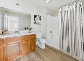 Thumbnail 34 of 53 - A bathroom with a white toilet, sink, and shower.