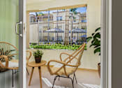 Thumbnail 32 of 53 - A balcony with a chair and table overlooking a building.