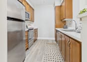 Thumbnail 35 of 53 - A kitchen with a refrigerator, microwave, and sink.