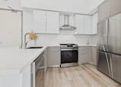 Thumbnail 39 of 163 - A modern kitchen with stainless steel appliances and white cabinetry.
