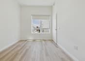 Thumbnail 47 of 163 - A room with a window and wooden flooring.