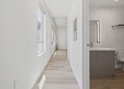Thumbnail 46 of 163 - A long, narrow hallway with a bathroom on the right.