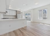 Thumbnail 65 of 163 - A kitchen with white cabinets and a wooden floor.