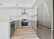Thumbnail 63 of 163 - A modern kitchen with stainless steel appliances and white cabinetry.