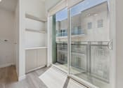 Thumbnail 72 of 163 - A room with a sliding glass door leading to a balcony.