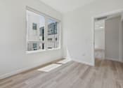Thumbnail 73 of 163 - A room with a large window and wooden flooring.