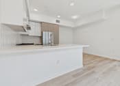 Thumbnail 80 of 163 - A kitchen with white countertops and a wooden floor.