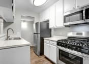Thumbnail 16 of 61 - a kitchen with white cabinets and stainless steel appliances